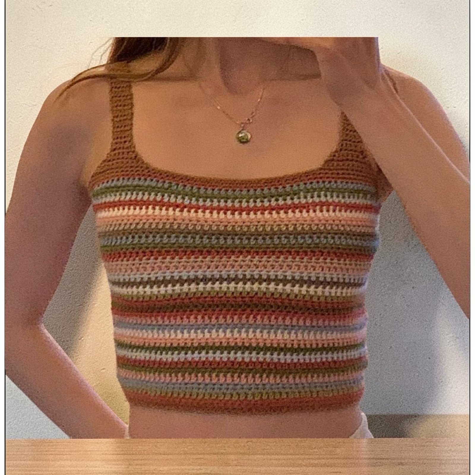 Woman wearing handmade multicolor crochet striped crop tank top with spaghetti straps