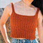 Woman wearing handmade burnt orange crochet ribbed crop tank top with straps