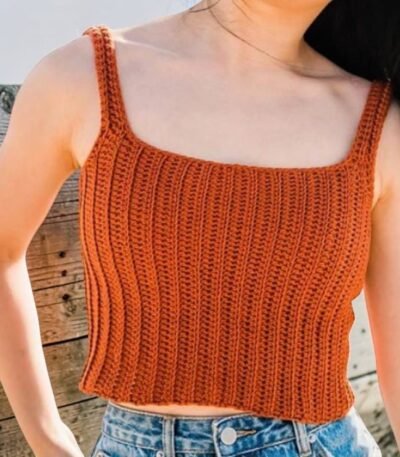 Woman wearing handmade burnt orange crochet ribbed crop tank top with straps