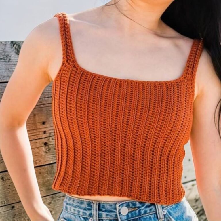 Woman wearing handmade burnt orange crochet ribbed crop tank top with straps
