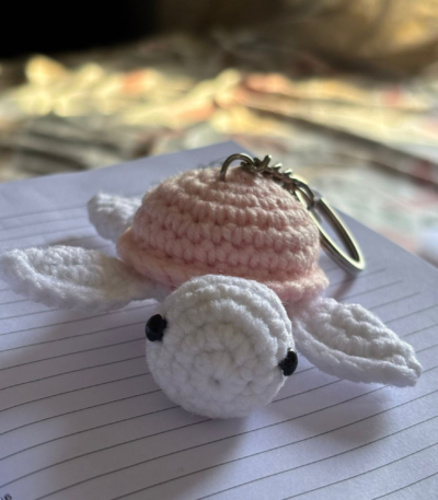handmade crochet turtle keychains in pastel colors placed on a white surface