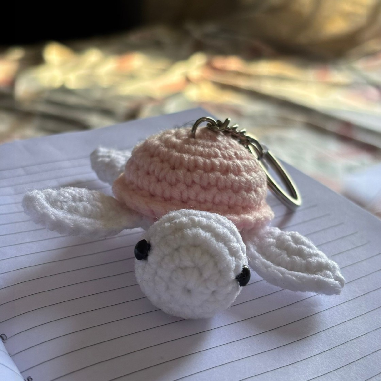 handmade crochet turtle keychains in pastel colors placed on a white surface